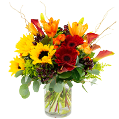  includes orange lilies, Gerber daisies, spray roses, calla lilies and assorted greens